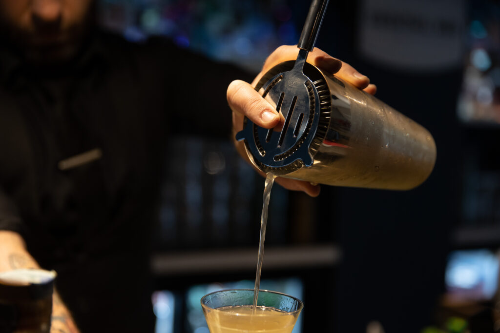 barman che filtra un cocktail con il filtro mixage
